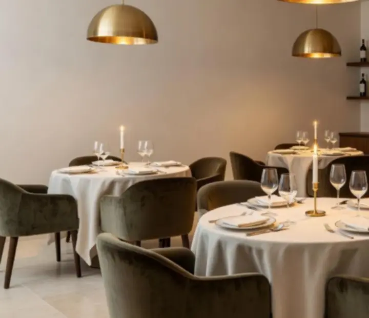 Sala de jantar elegante com mesas bem postas e luz suave num restaurante de luxo.